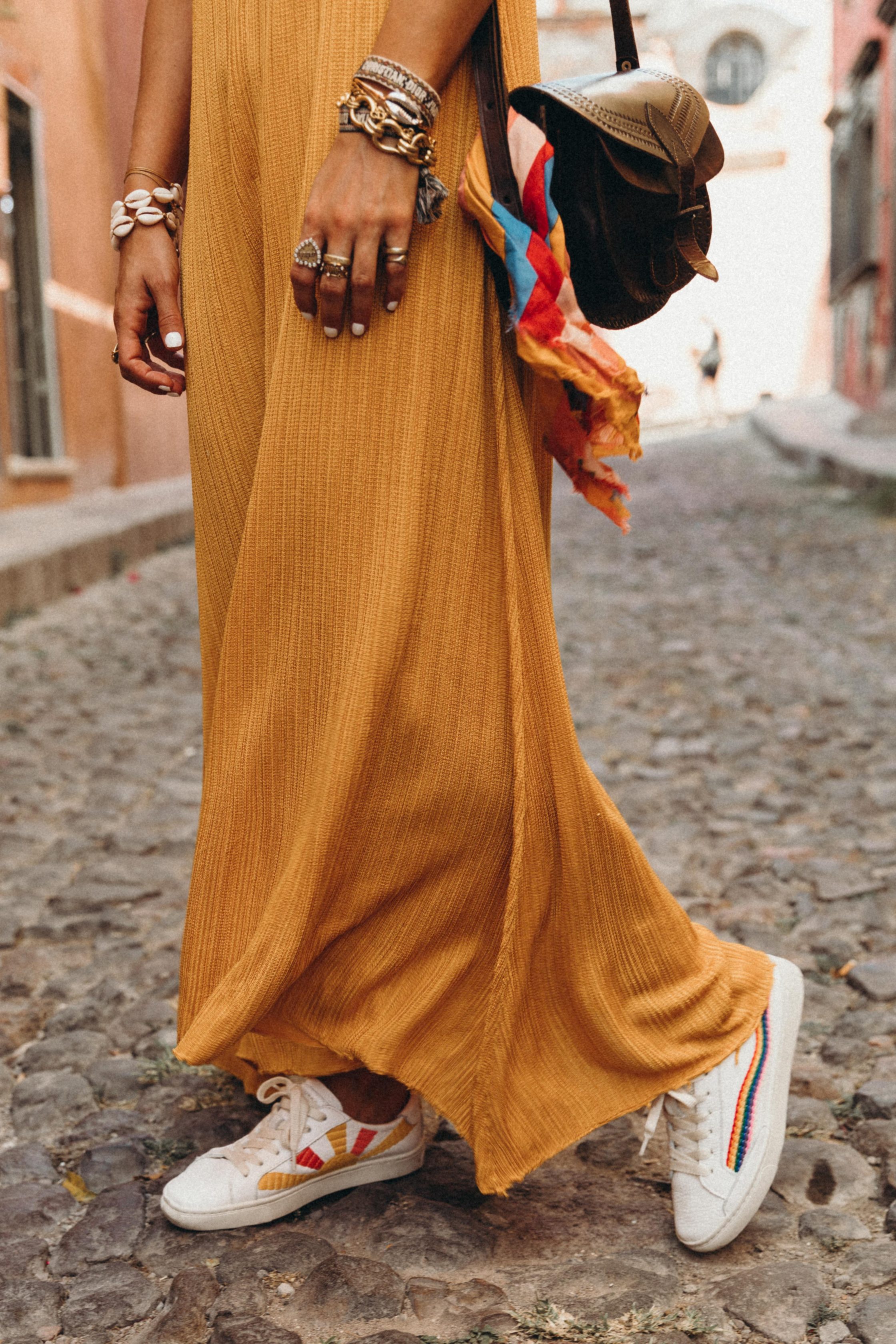 Sara of Collage Vintage wearing a long mustard dress and embroidered sneakers
