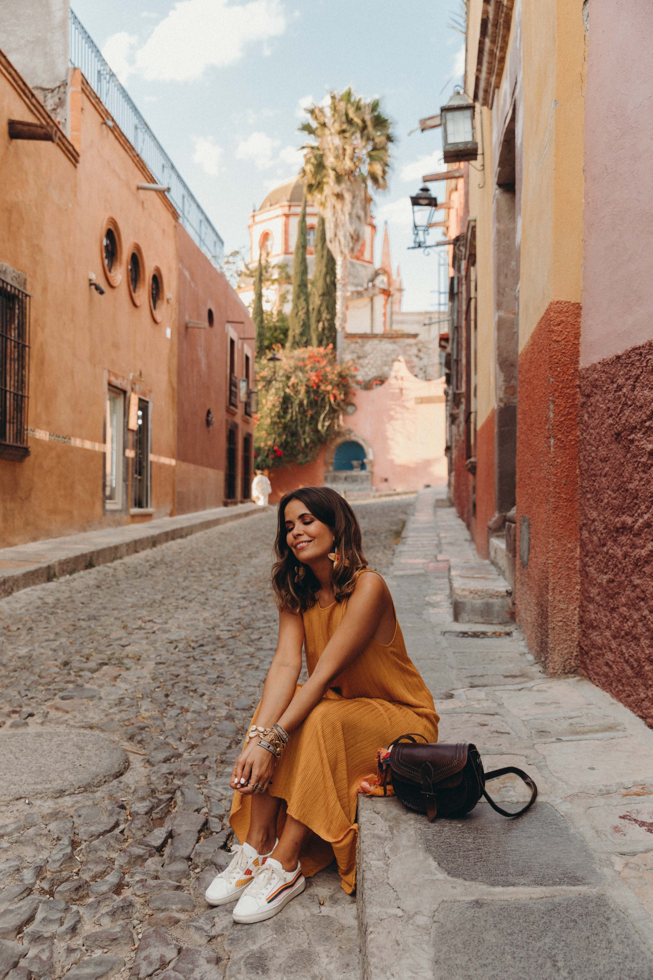Sara of Collage Vintage wearing a long mustard dress and embroidered sneakers