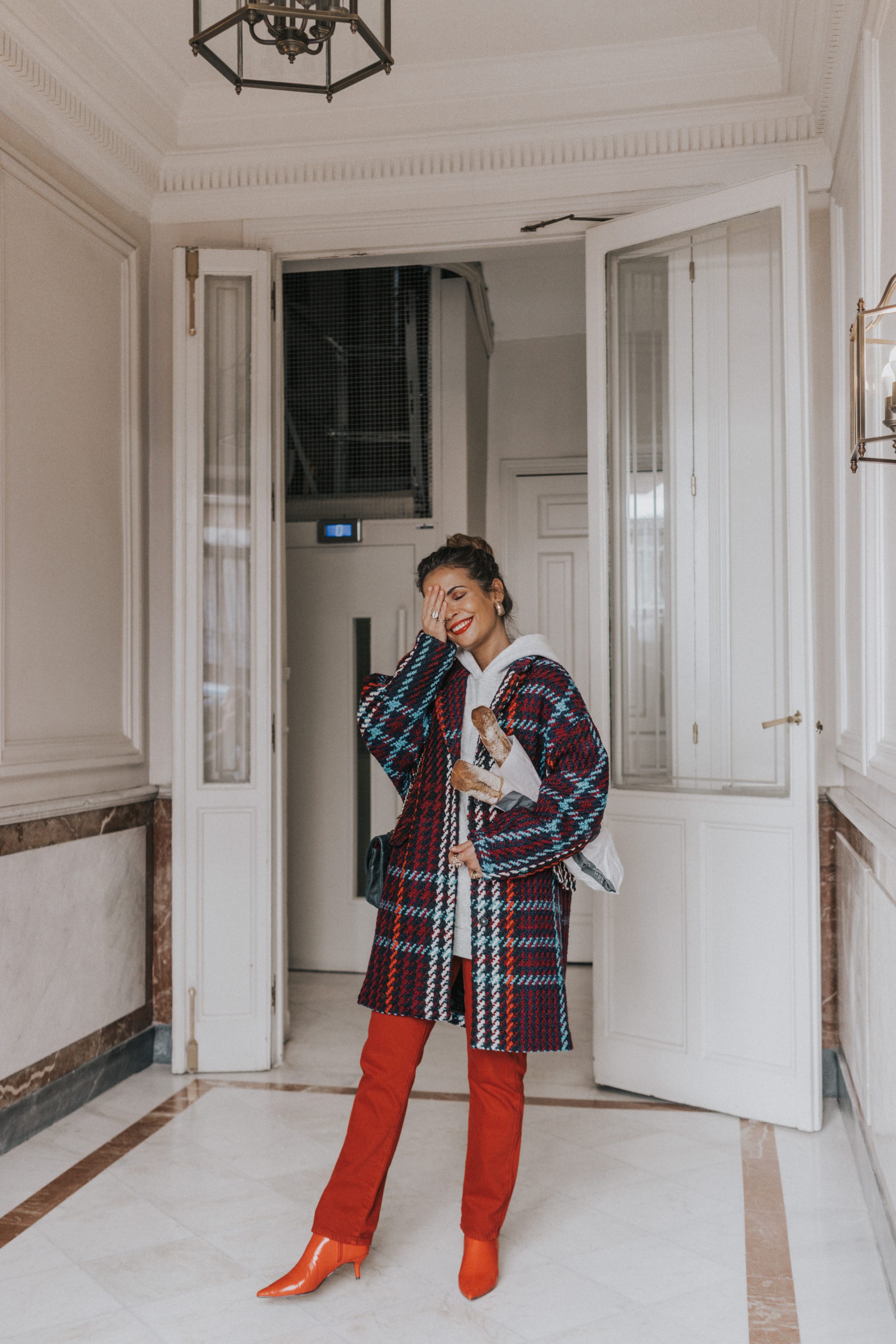 Sara of Collage Vintage wearing plaid coat and red trousers