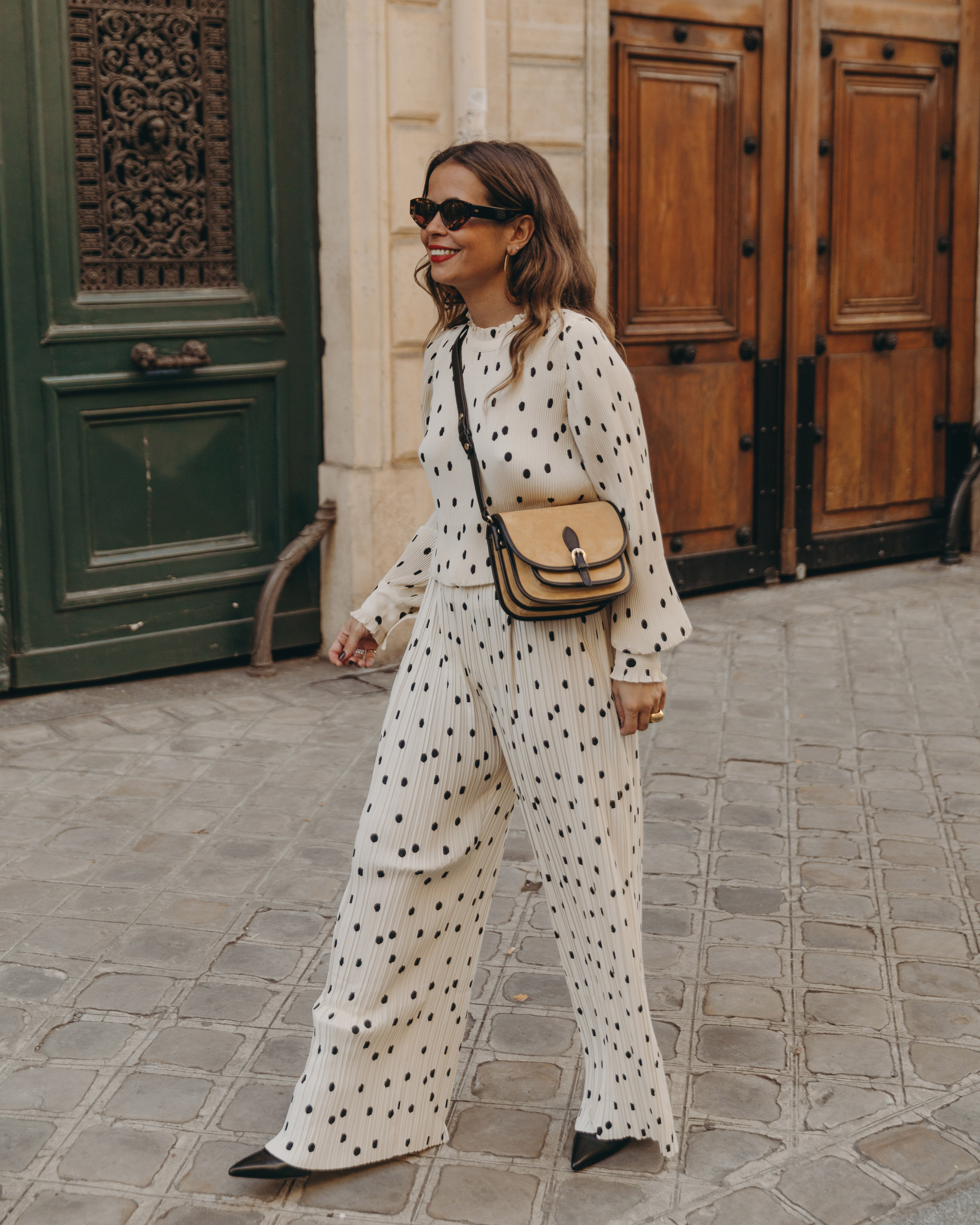 Sara from Collage Vintage at Saint Germain Paris wearing a Sézane polka dots set and a leather crossbody bag.
